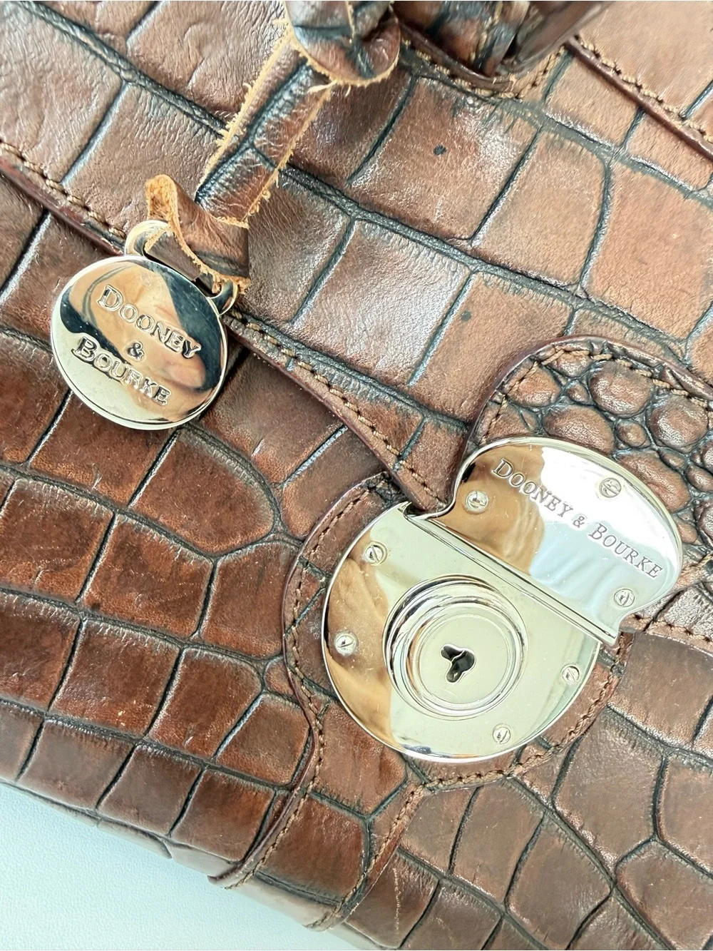 Dooney & Bourke, crafted from rich brown crocodile-embossed leather